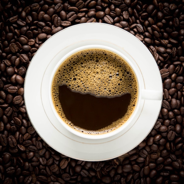 Xícara de café e grãos de café na mesa de madeira