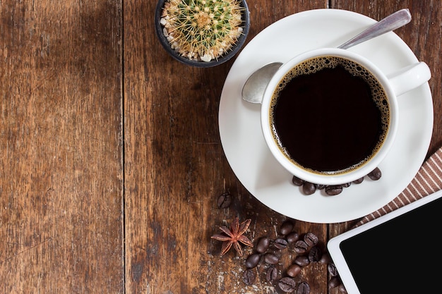 Xícara de café e grãos de café na mesa de madeira