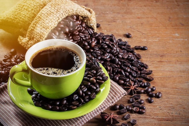 Xícara de café e grãos de café na mesa de madeira