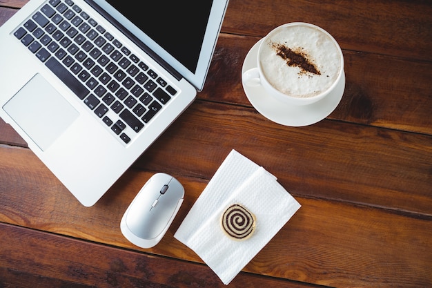 Xícara de café e laptop em uma mesa