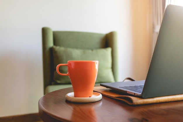 Xícara de café e laptop na mesa no café.