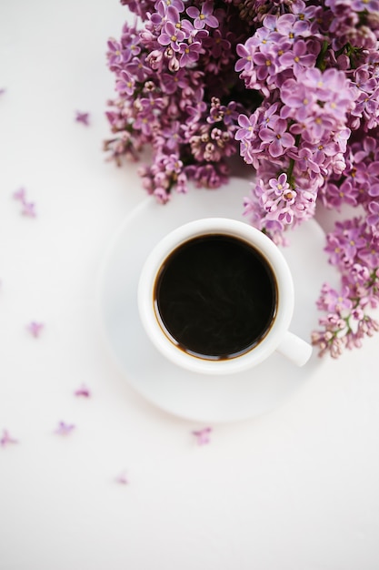 Foto xícara de café e lilás ramo em branco