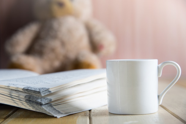 Xícara de café e livro focado em ursinho de pelúcia