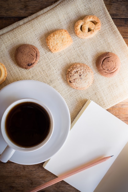 Xícara de café e muitas formas de biscoito