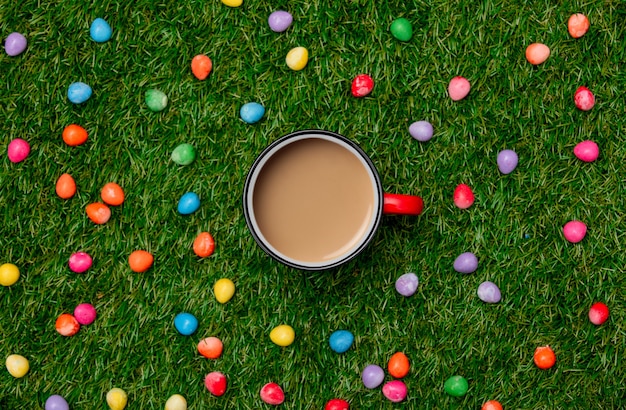 Xícara de café e ovos de chocolate da Páscoa na grama verde