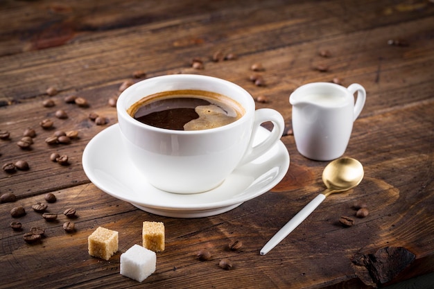 Xícara de café e pires em uma mesa de madeira Fundo escuro