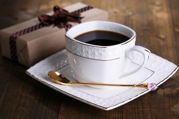 Foto xícara de café e presente em close-up de mesa de madeira