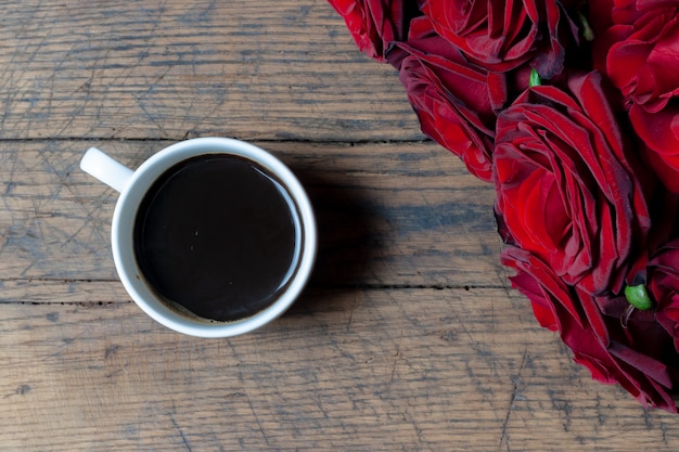 xícara de café e rosas vermelhas