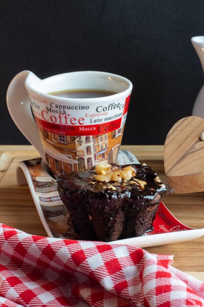 Foto xícara de café e um caramelo de chocolate debaixo da mesa de madeira