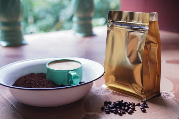 Foto xícara de café em grãos de café fresco e pó moído