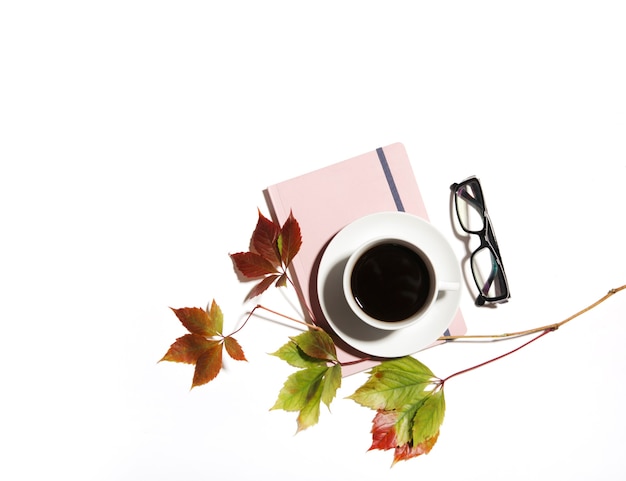 Xícara de café em um caderno e folhas