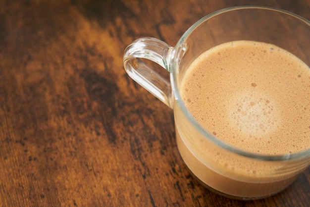 Foto xícara de café espumante dolce gusto latte na mesa de madeira