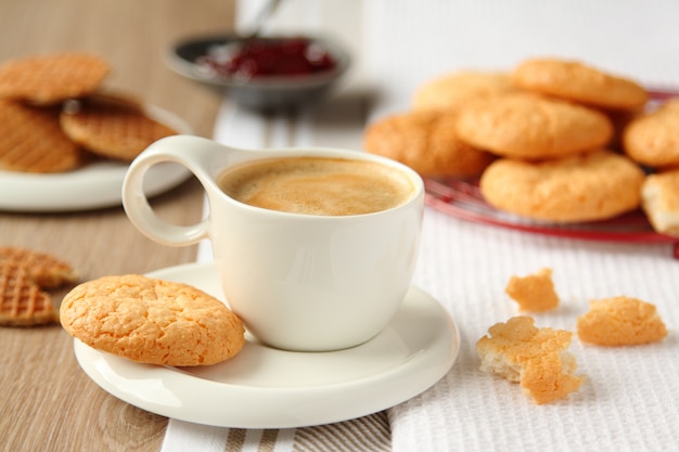 Xícara de café expresso com biscoitos de coco em um prato