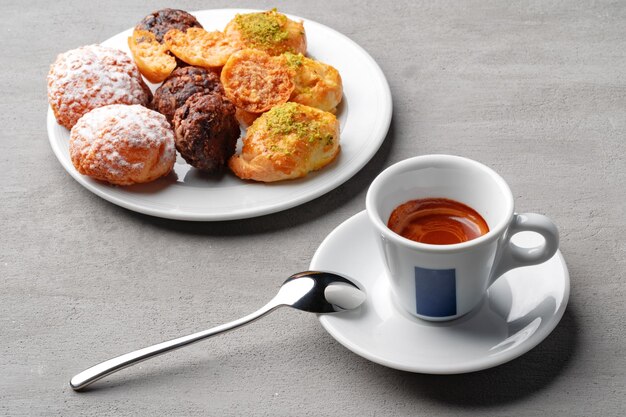 Xícara de café expresso e biscoitos em uma mesa cinza