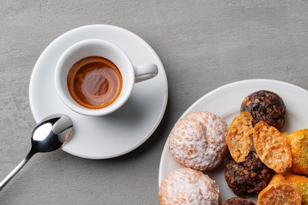 Xícara de café expresso e biscoitos em uma mesa cinza