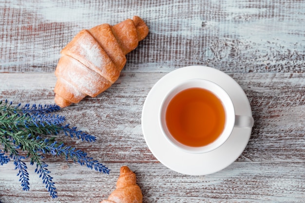 Xícara de café expresso e croissant em fundo amarelo, copie o espaço