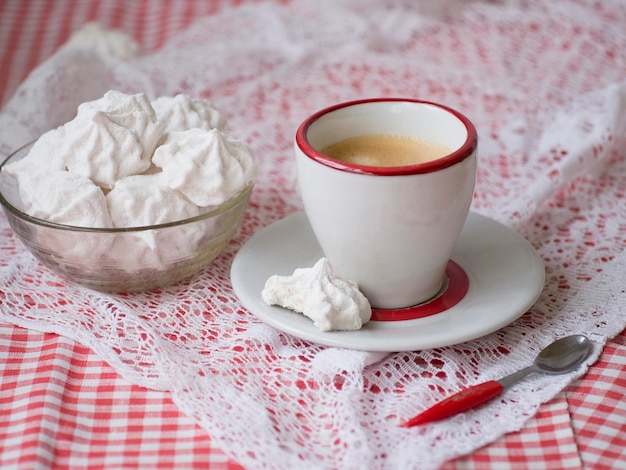 Foto xícara de café expresso e zéfiro caseiro ou marshmallow em uma placa de vidro