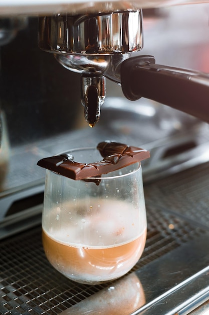 Xícara de café fresca com barra de chocolate na mesa