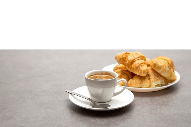 Xícara de café fresco com croissants em fundo escuro