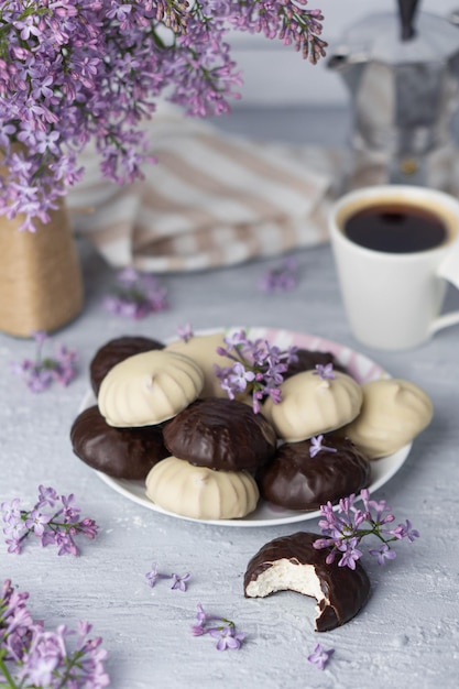 Xícara de café lilás marshmallow em esmalte de chocolate escuro e branco na cafeteira de placa