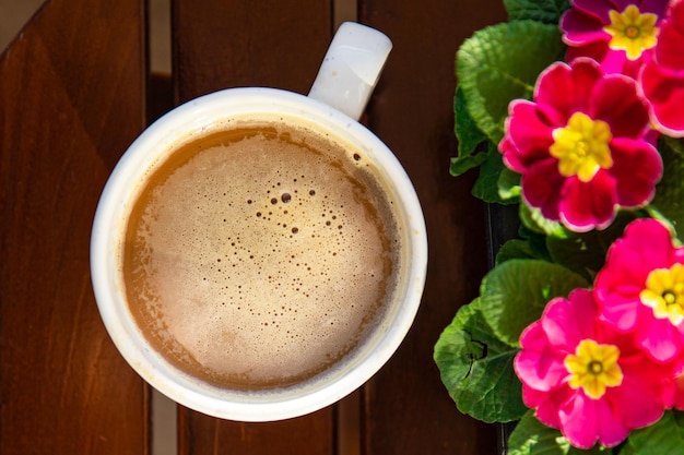 xícara de café na mesa ao ar livre e flores prímula cópia multicolorida espaço comida fundo