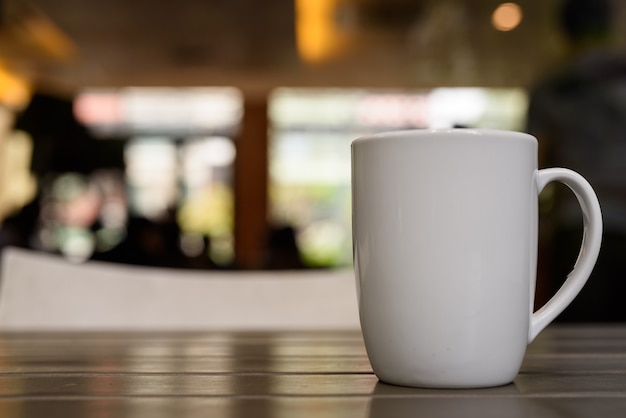 Xícara de café na mesa de madeira em restaurante com desfocado