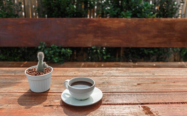 Xícara de café na mesa de madeira no sol da manhã