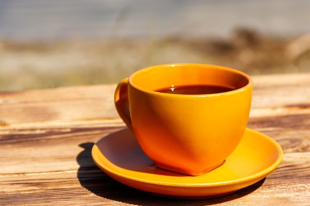 Xícara de café na mesa de madeira perto do rio