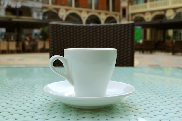 Xícara de café na mesa de vidro na cafeteria ao ar livre