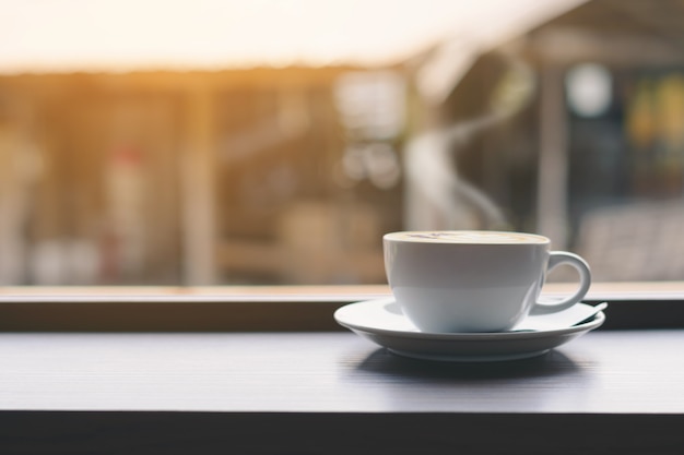 Xícara de café na mesa e janela de fundo