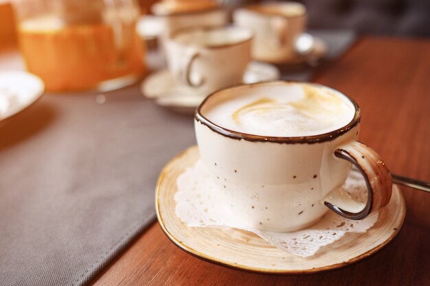 Xícara de café na mesa, latte art, luz do sol