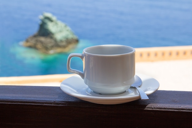 Xícara de café na varanda com linda vista para o mar