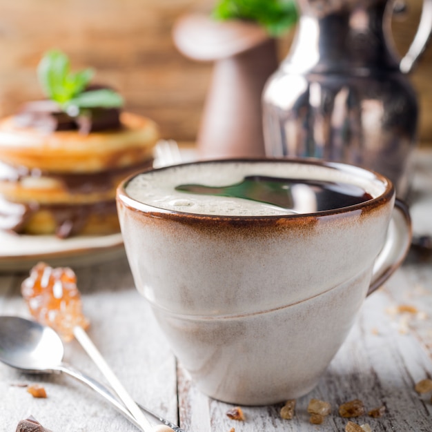 Xícara de café no café da manhã com panquecas.