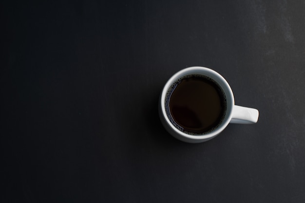 Xícara de café no fundo preto. foco suave.