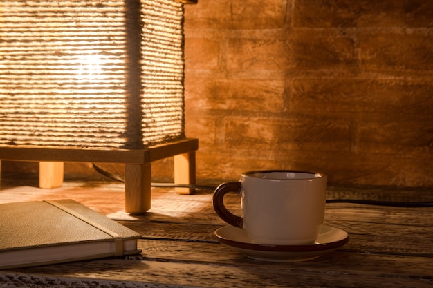 Xícara de café, notebook e candeeiro de mesa vintage
