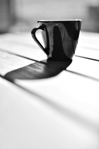 Xícara de café preta em uma mesa branca em estilo retrô com espaço para texto