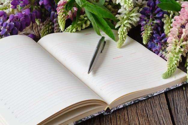 Xícara de café preto, buquê de flores e folha de papel vazia