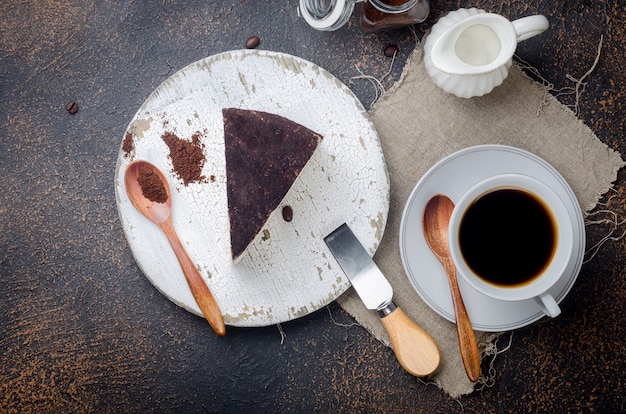 Xícara de café preto com um pedaço de queijo no café moído