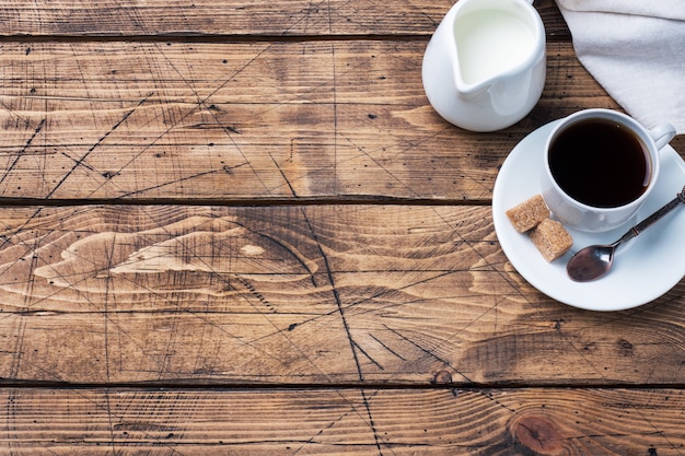 Xícara de café preto e leite em uma mesa de madeira. Copie o espaço.