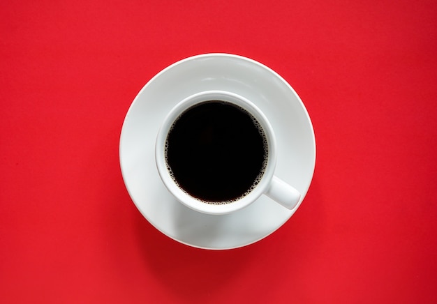 Xícara de café preto em fundo vermelho