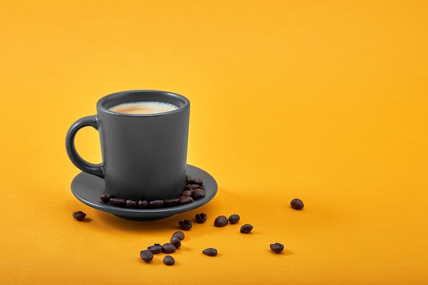 Xícara de café preto em um fundo amarelo conceito bom dia, impulso de energia, motivação