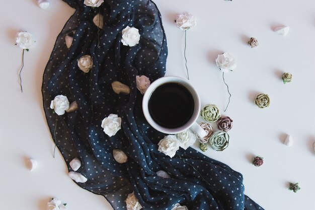 xícara de café quente com flores e tecido