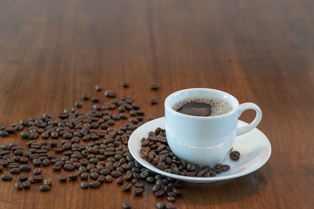 Xícara de café quente com grãos de café torrados