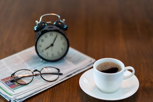 Xícara de café quente com jornal de manhã