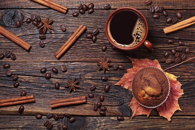 Xícara de café quente e bolinho de chocolate na mesa de madeira escura, vista superior