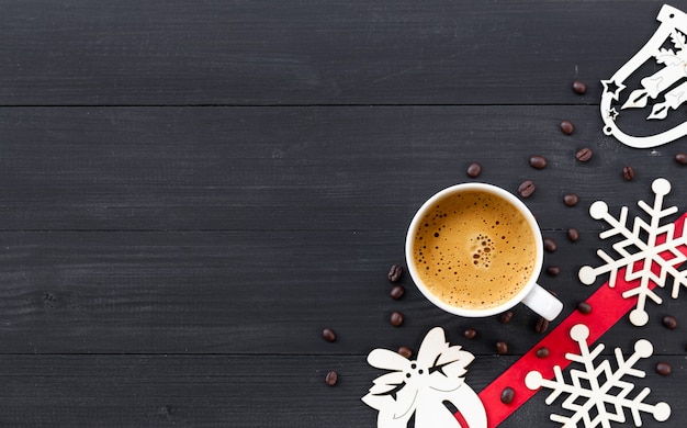 Xícara de café quente na superfície de madeira preta na época do Natal