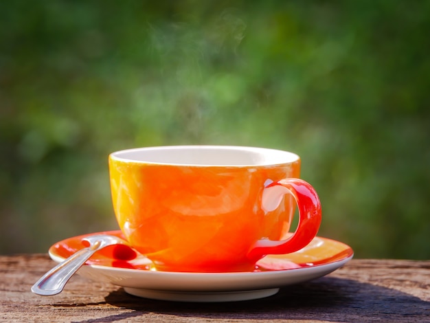 Xícara de café quente no fundo verde natural no tempo da manhã