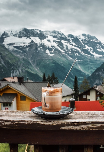 Xícara de café quente no terraço do café Jungfrau vista da montanha na vila dos Alpes suíços na Suíça