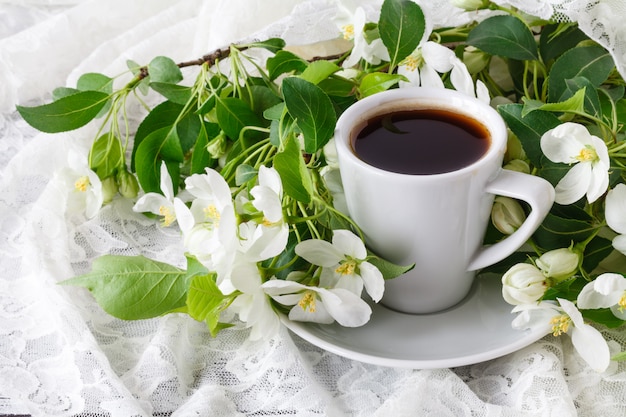 Xícara de café saboroso quente em ambiente floral muito primavera.