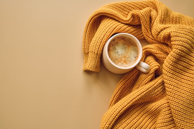 Xícara de café, suéter amarelo